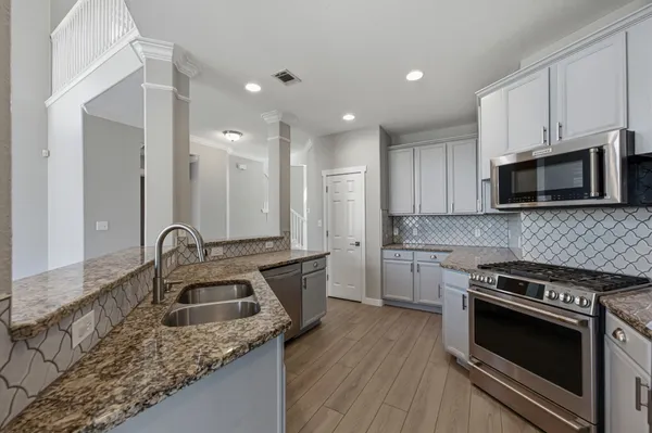 a kitchen with stainless steel appliances granite countertop a sink stove and microwave