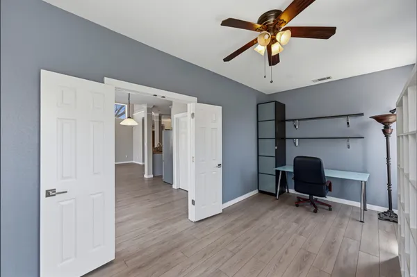 a view of a workspace with furniture and a ceiling fan