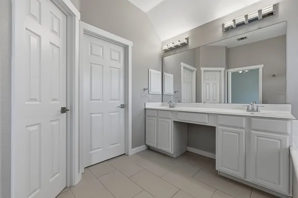 a bathroom with a double vanity sink and a mirror