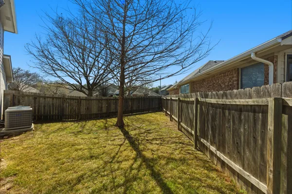 a view of backyard with wooden fence