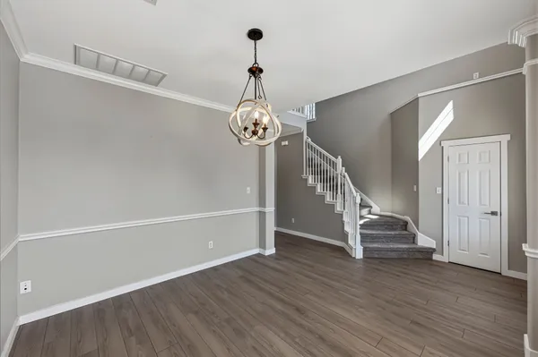 a view of a hallway with wooden floor and staircase