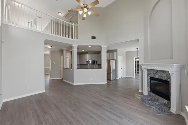 a view of a hallway with wooden floor and a kitchen