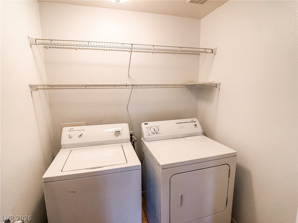 7701 West Robindale Road, Unit 110 Las Vegas, NV 89113 - Photo 15 of 21 Functional laundry room equipped with washer, dryer, and convenient overhead shelving for storage.