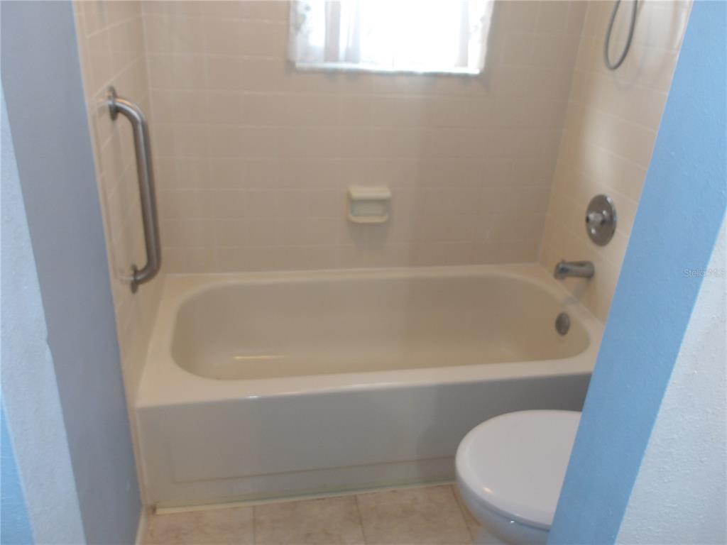 4140 Passport Lane, Unit 101 New Port Richey, FL 34653 - Photo 27 of 40 a white bath tub sitting next to a toilet