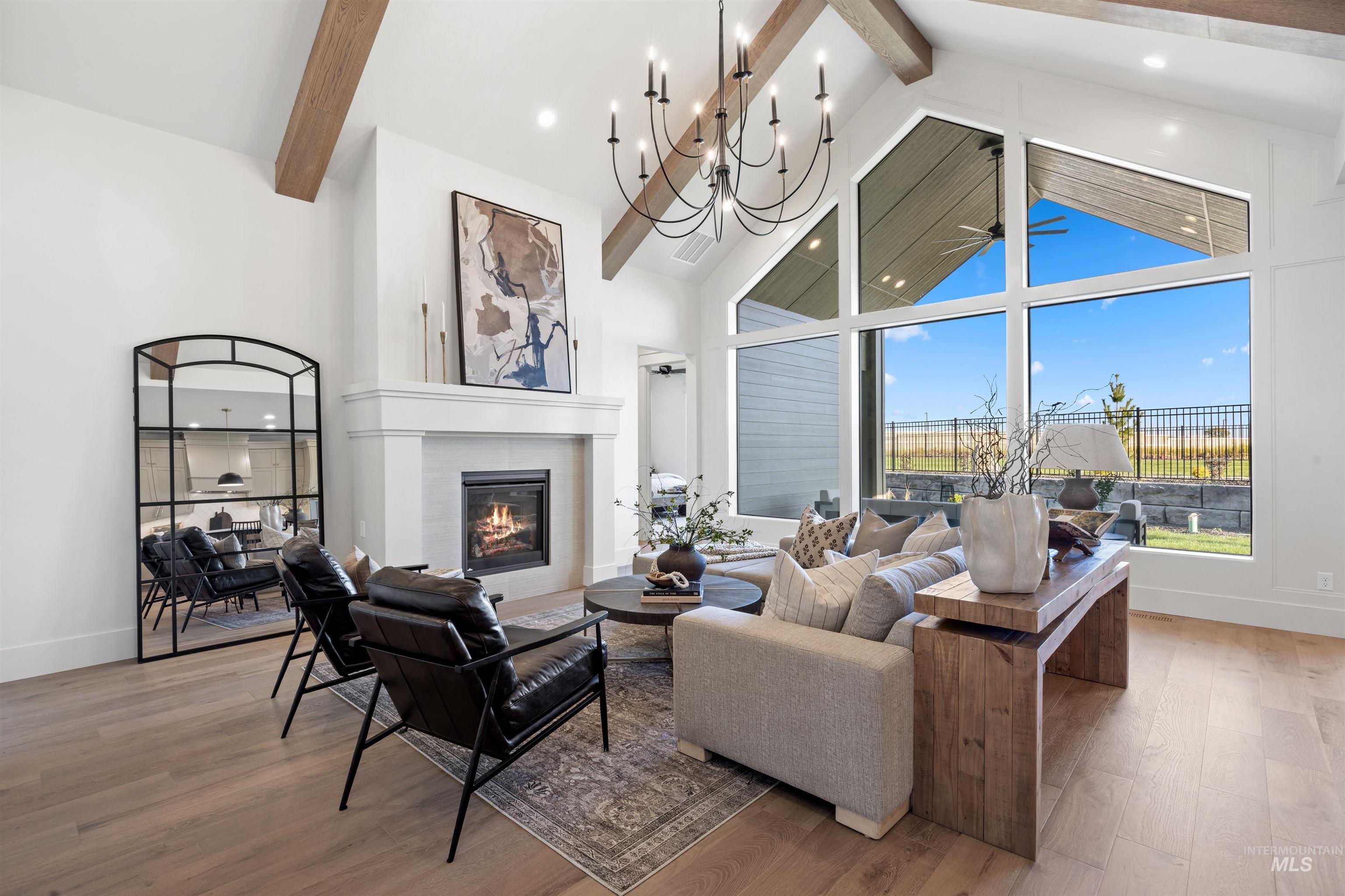 5847 South Pinpoint Way Meridian, ID 83642 - Photo 10 of 44 Living area featuring light wood-type flooring, a fireplace, hanging lights, and a ceiling fan