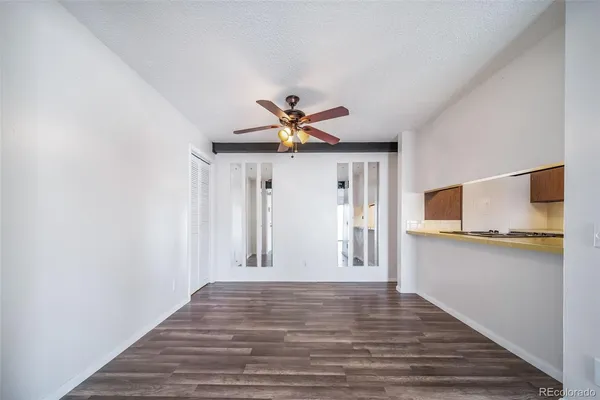 a view of a livingroom with wooden floor and a ceiling fan