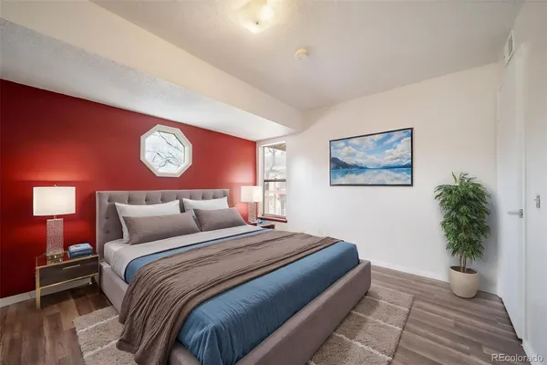 a bedroom with a large bed and a potted plant