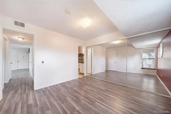 a view of empty room with wooden floor