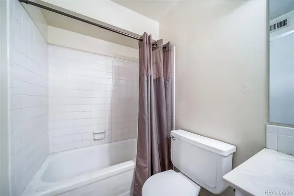 a white toilet sitting next to a bathtub