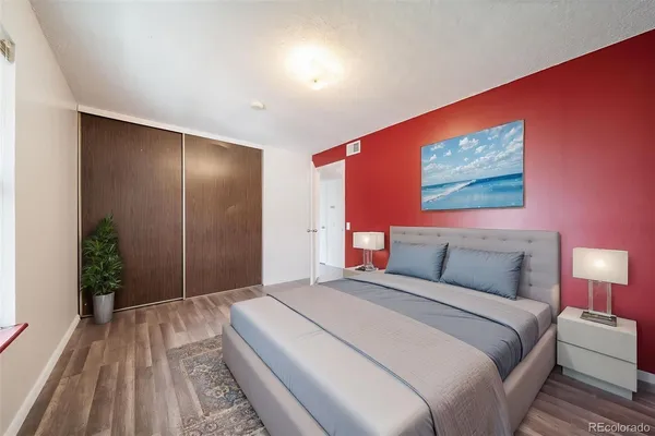 a bedroom with a large bed and a potted plant