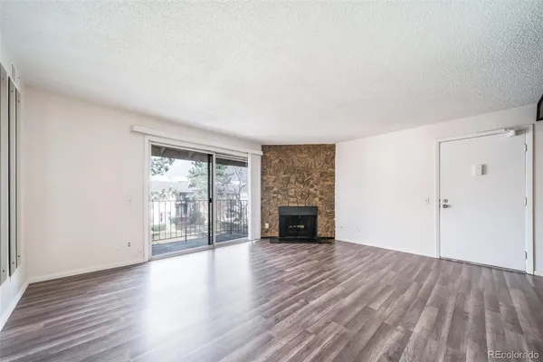 a view of empty room with wooden floor and fireplace