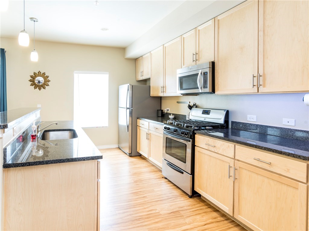 2606 Wilson Street, Unit 1601 Austin, TX 78704 - Photo 4 of 14 a kitchen with stainless steel appliances granite countertop a sink stove and refrigerator