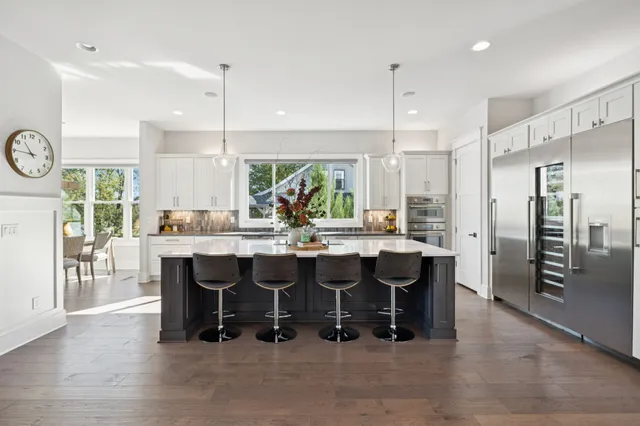 a kitchen with stainless steel appliances granite countertop a sink a stove and a wooden floors