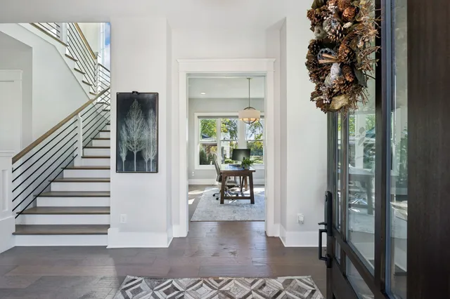 a dining hall with stainless steel appliances kitchen island granite countertop furniture wooden floor and a view of living room