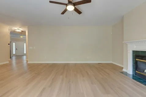 a kitchen with stainless steel appliances granite countertop a stove a sink a refrigerator and white cabinets with wooden floor