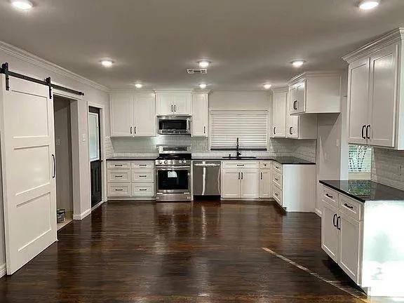 a kitchen with stainless steel appliances granite countertop a refrigerator sink and cabinets
