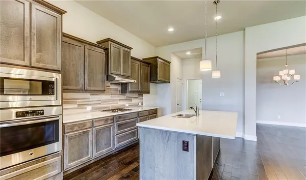 a kitchen with a sink stainless steel appliances and cabinets