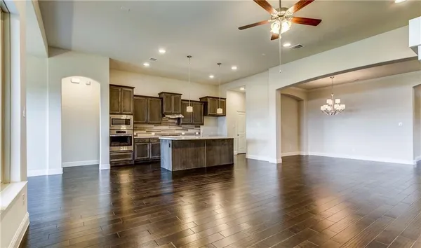 a large white kitchen with a refrigerator and a stove top oven