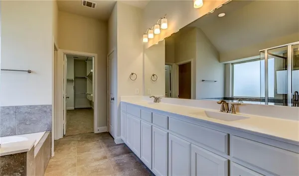 a bathroom with a double vanity sink and a mirror