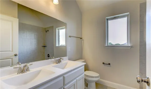 a bathroom with a granite countertop toilet a sink and a mirror