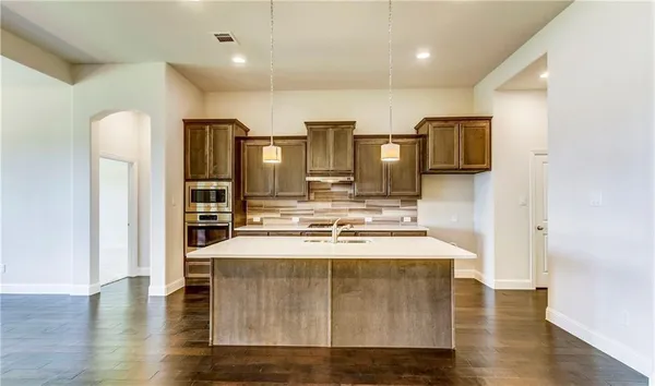a kitchen with stainless steel appliances granite countertop a sink a stove and a refrigerator