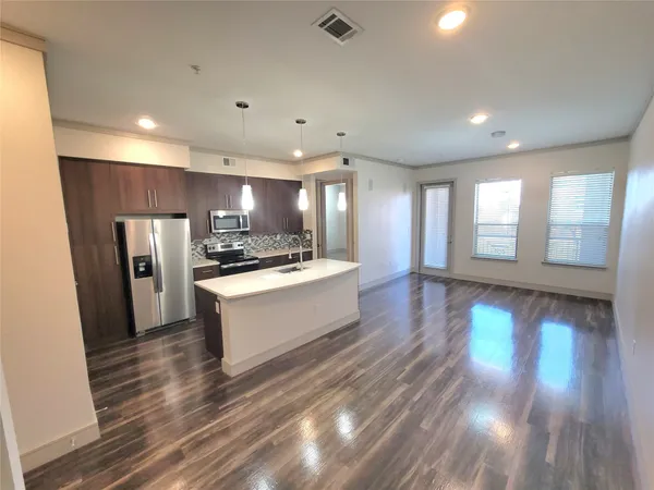 a large kitchen with stainless steel appliances a large counter top and a stove