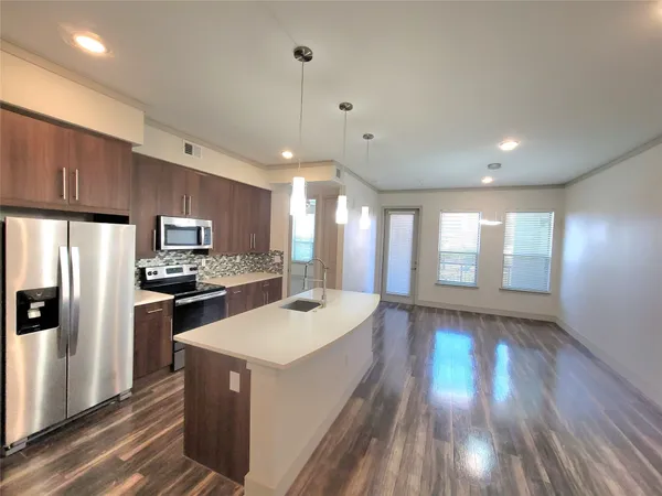 a kitchen with a refrigerator a sink and wooden floor