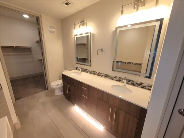 a bathroom with a double vanity sink a mirror and a shower