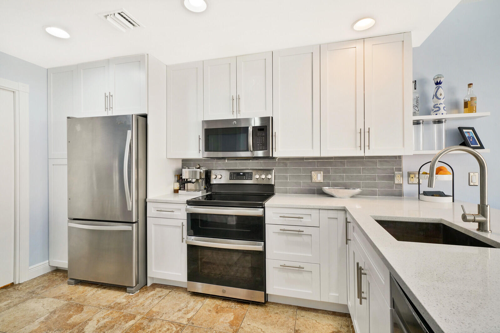 1615 Frederick Small Road Jupiter, FL 33458 - Photo 11 of 32 a kitchen with refrigerator a microwave and cabinets