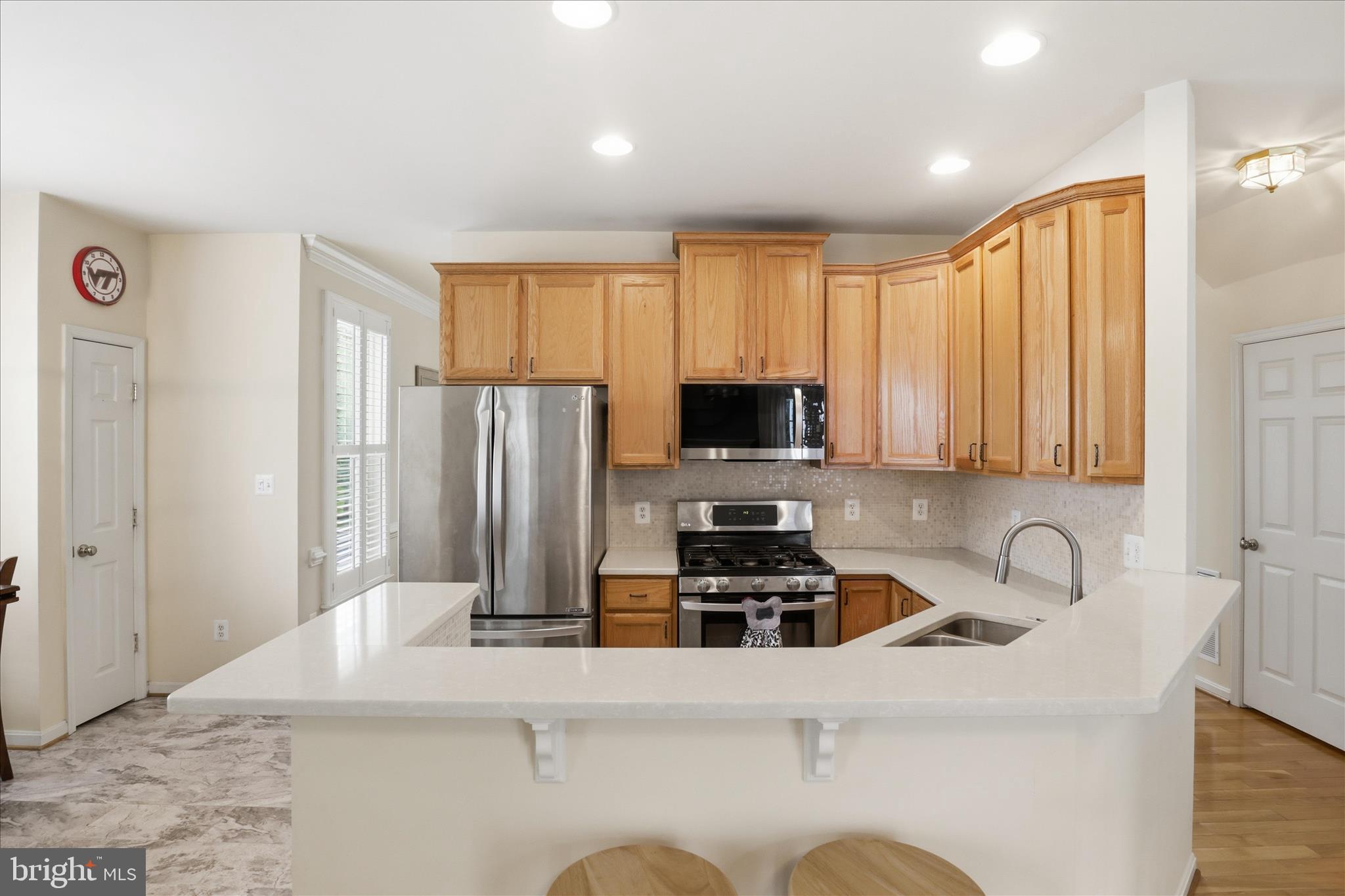 25352 Ripleys Field Drive Chantilly, VA 20152 - Photo 4 of 54 a kitchen with stainless steel appliances a stove a sink a refrigerator a microwave a refrigerator and cabinets