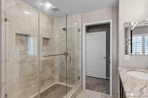 a bath room with a granite countertop sink and a bathtub