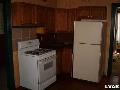 31 North 3rd Street Coplay, PA 18037 - Photo 2 of 11 a white refrigerator freezer and a stove sitting inside of a kitchen