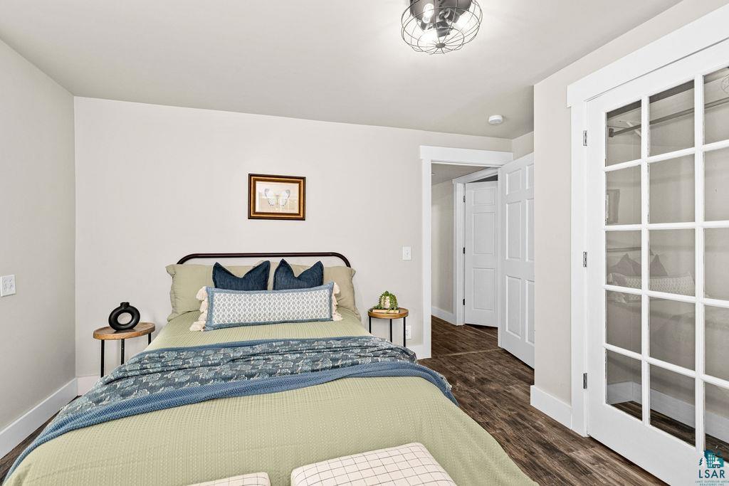 5025 Reid Road Duluth, MN 55803 - Photo 32 of 51 French doors with white trim and grid patterns, wood-finish flooring, a contemporary semi-flush mount light fixture, and solid core interior doors