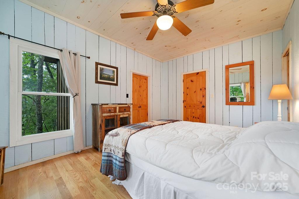 418 Sandy Lane Brevard, NC 28712 - Photo 30 of 45 a bedroom with a bed next to a window with a flat screen tv
