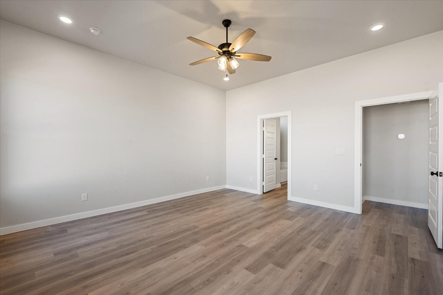 7426 30th Street Lubbock, TX 79407 - Photo 14 of 25 an empty room with wooden floor and ceiling fan