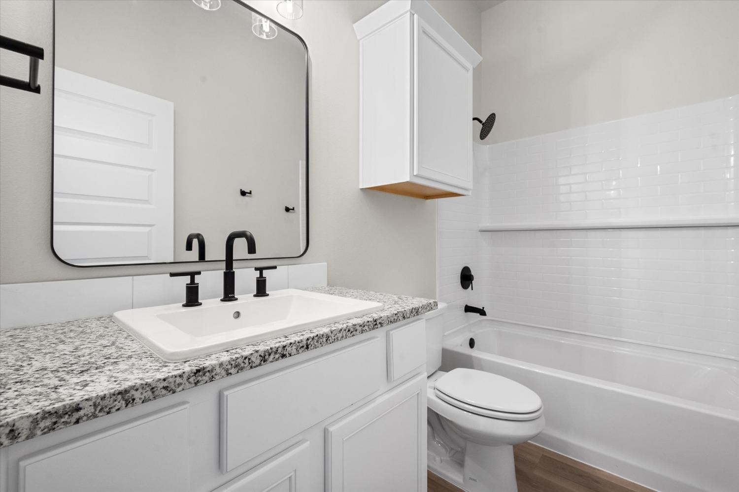 7426 30th Street Lubbock, TX 79407 - Photo 21 of 25 a bathroom with a granite countertop sink toilet and shower