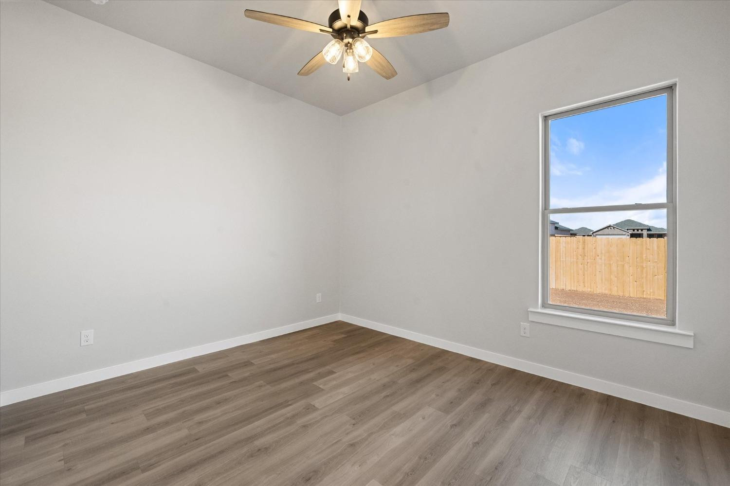 7426 30th Street Lubbock, TX 79407 - Photo 22 of 25 an empty room with a window and wooden floor