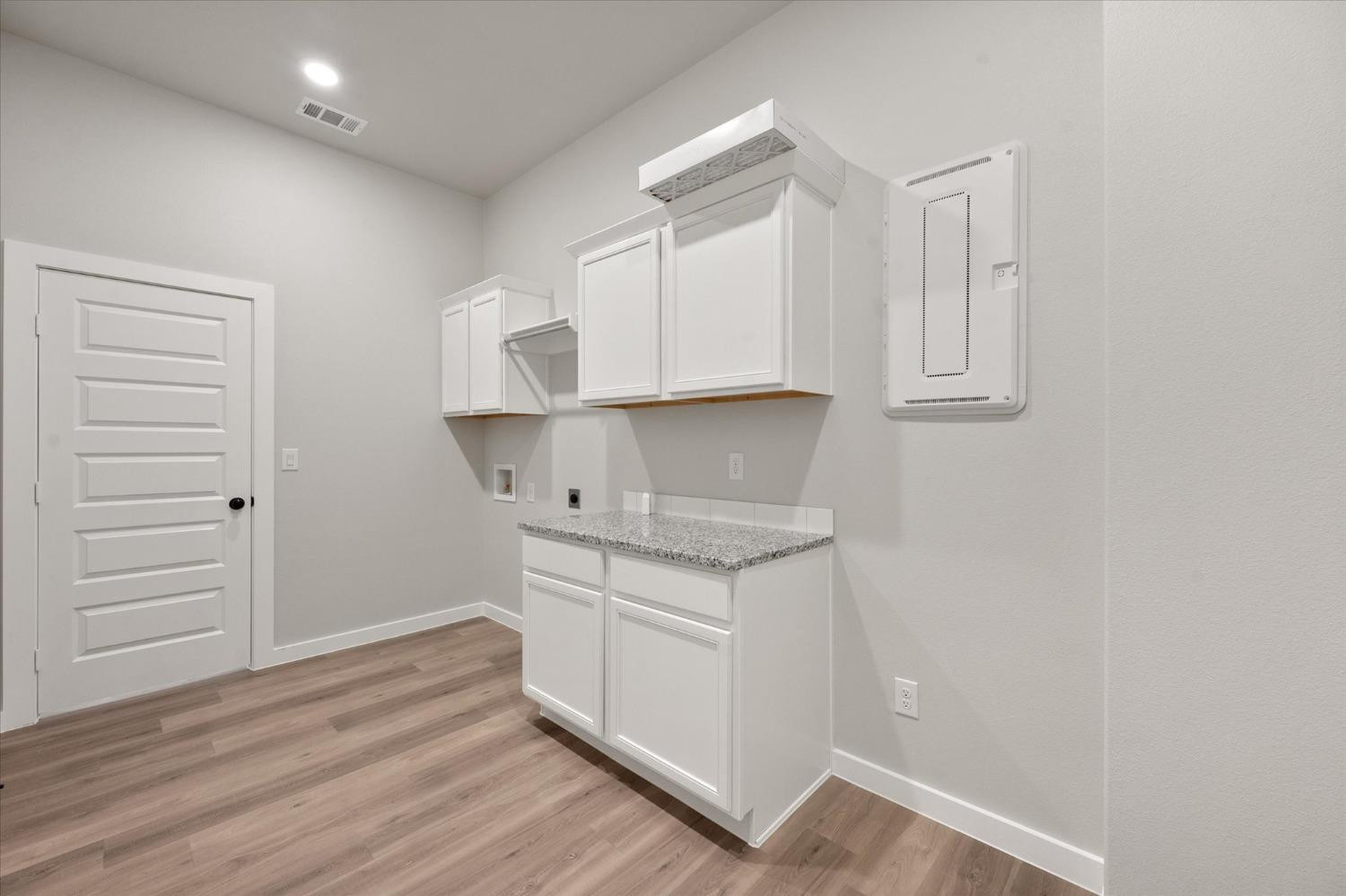7426 30th Street Lubbock, TX 79407 - Photo 24 of 25 a kitchen with granite countertop white cabinets and white appliances
