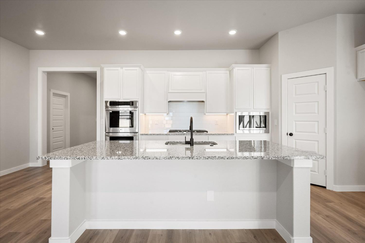 7426 30th Street Lubbock, TX 79407 - Photo 5 of 25 a view of kitchen with kitchen island a sink stainless steel appliances and white cabinets