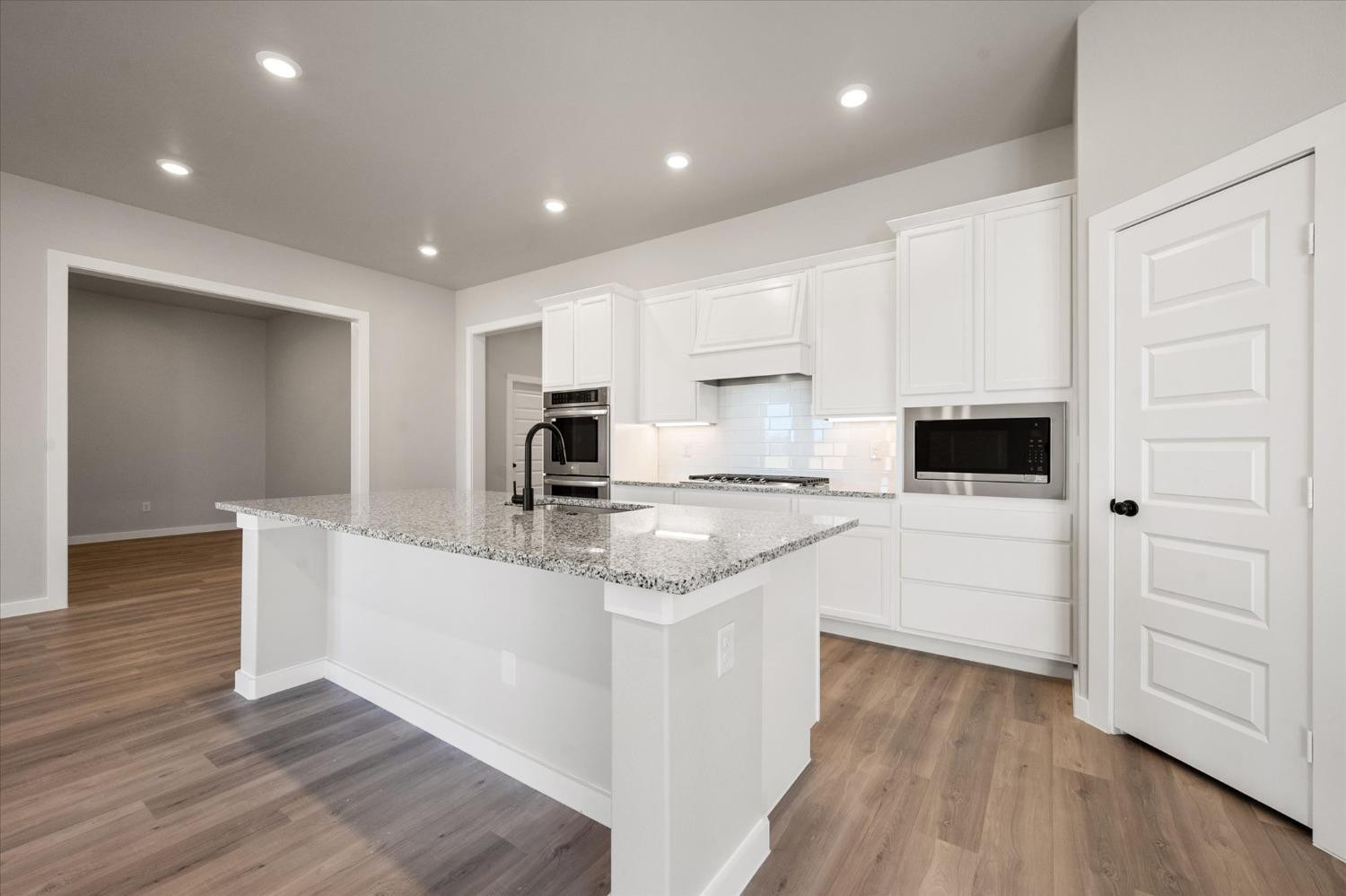 7426 30th Street Lubbock, TX 79407 - Photo 6 of 25 a kitchen with white cabinets and stainless steel appliances