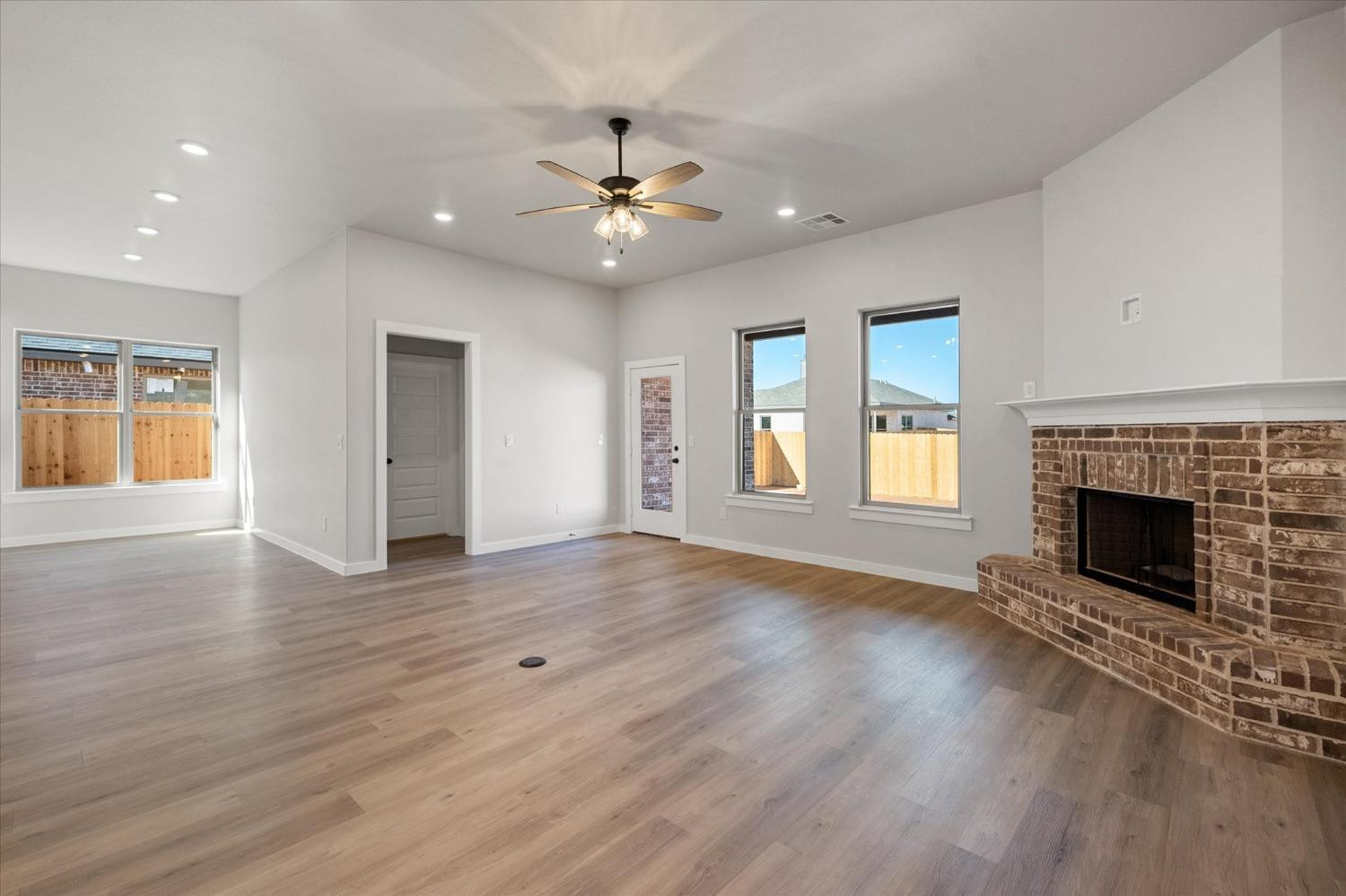 7426 30th Street Lubbock, TX 79407 - Photo 10 of 25 an empty room with wooden floor fireplace and window