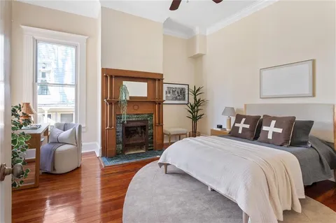a spacious bedroom with a bed and wooden floor