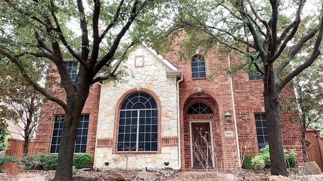a view of front of a house with yard and tree s