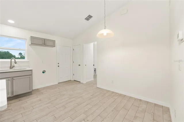 a view of an empty room with window and cabinet