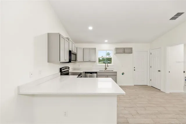a kitchen with a sink a stove and cabinets