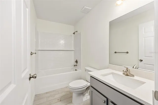 a bathroom with a sink toilet vanity and shower