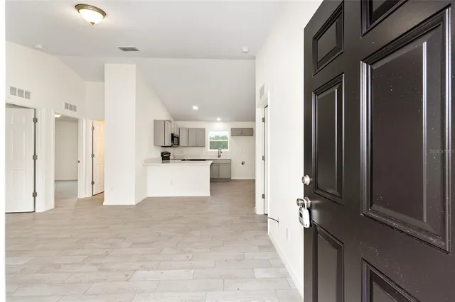 a view of a kitchen with refrigerator and a sink