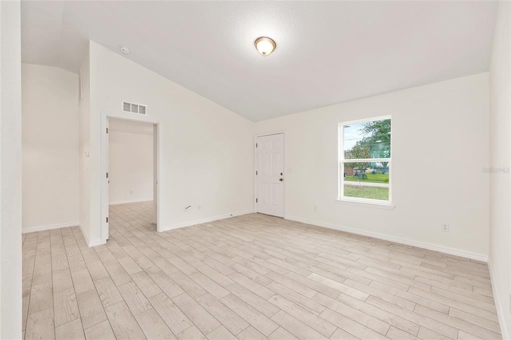 229 Locust Lane Ocala, FL 34472 - Photo 8 of 28 an empty room with wooden floor and windows