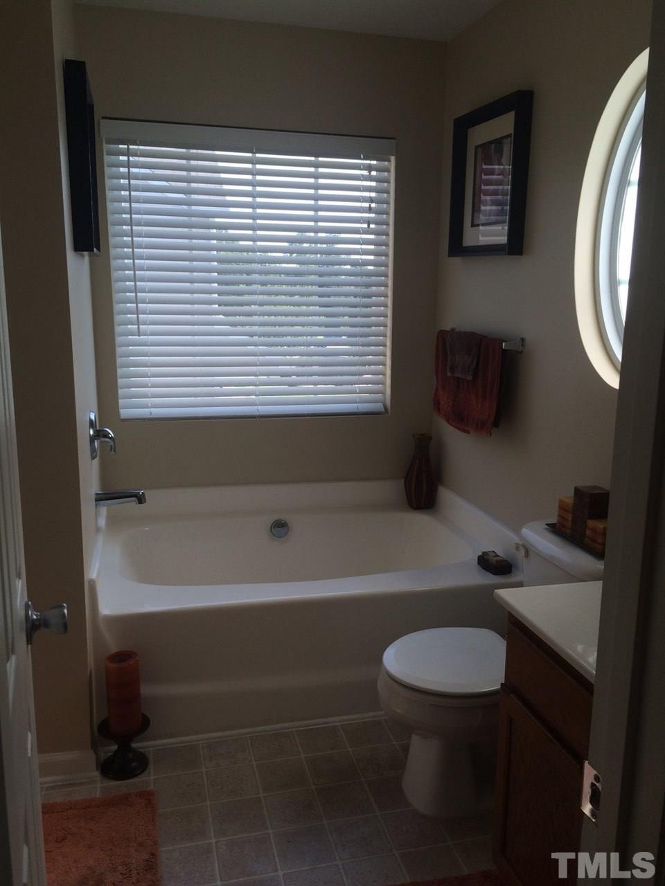 3822 Potecasi Drive Raleigh, NC 27610 - Photo 8 of 12 a bathroom with a sink a toilet and a bathtub