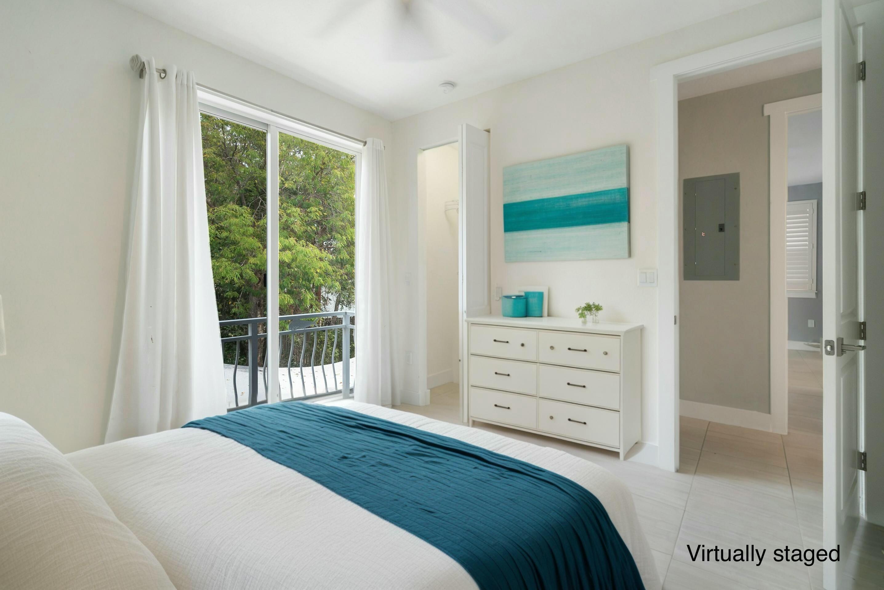 582 Boyd Drive Key Largo, FL 33037 - Photo 12 of 36 a bedroom with a bed and a dresser